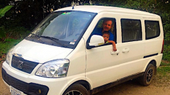 White seven-seater with man and child inside