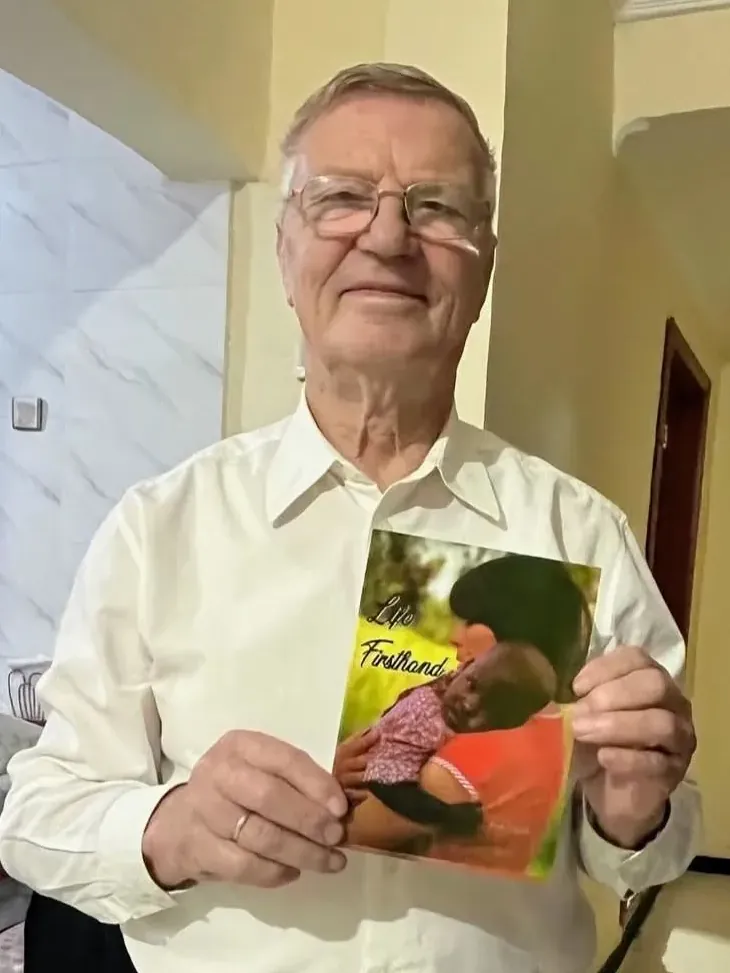 Paul Kowoll holding the English edition of his autobiography Life Firsthand during the 40th anniversary celebrations at Akaki Children’s Village.